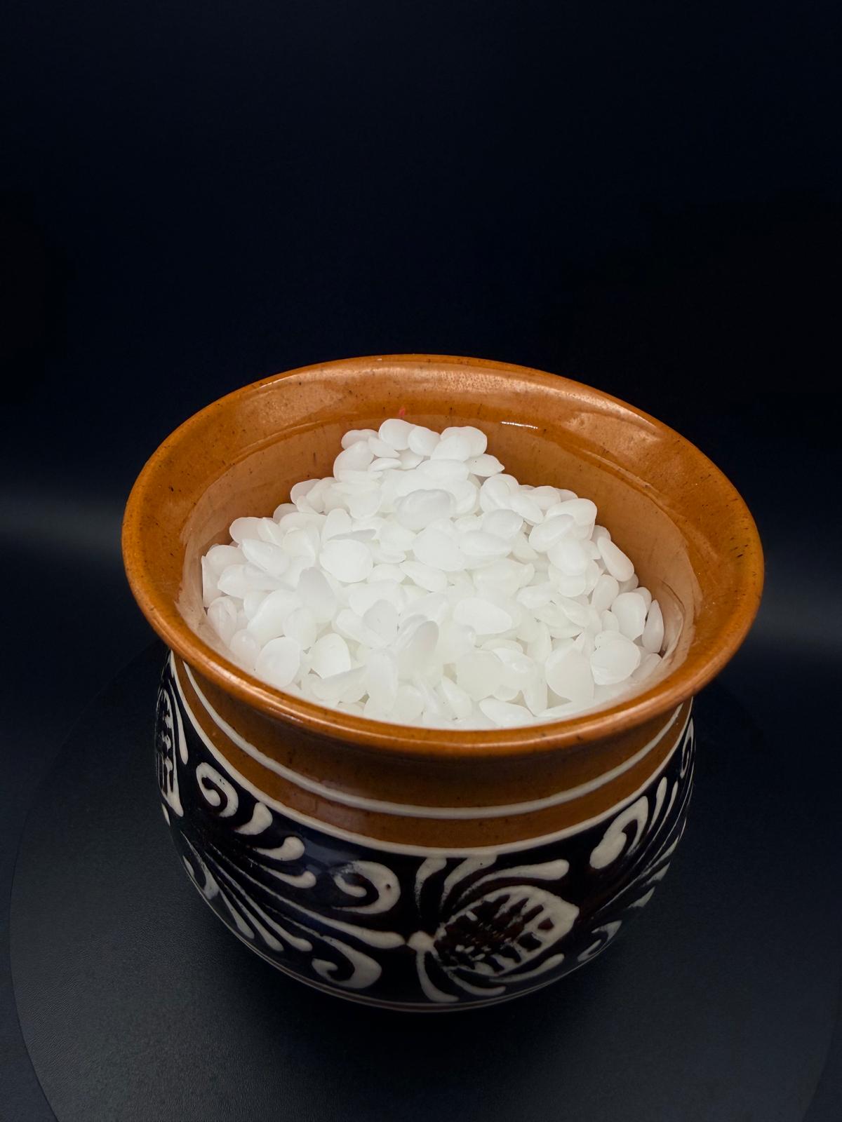 Natural beeswax granules in a traditional ceramic cup