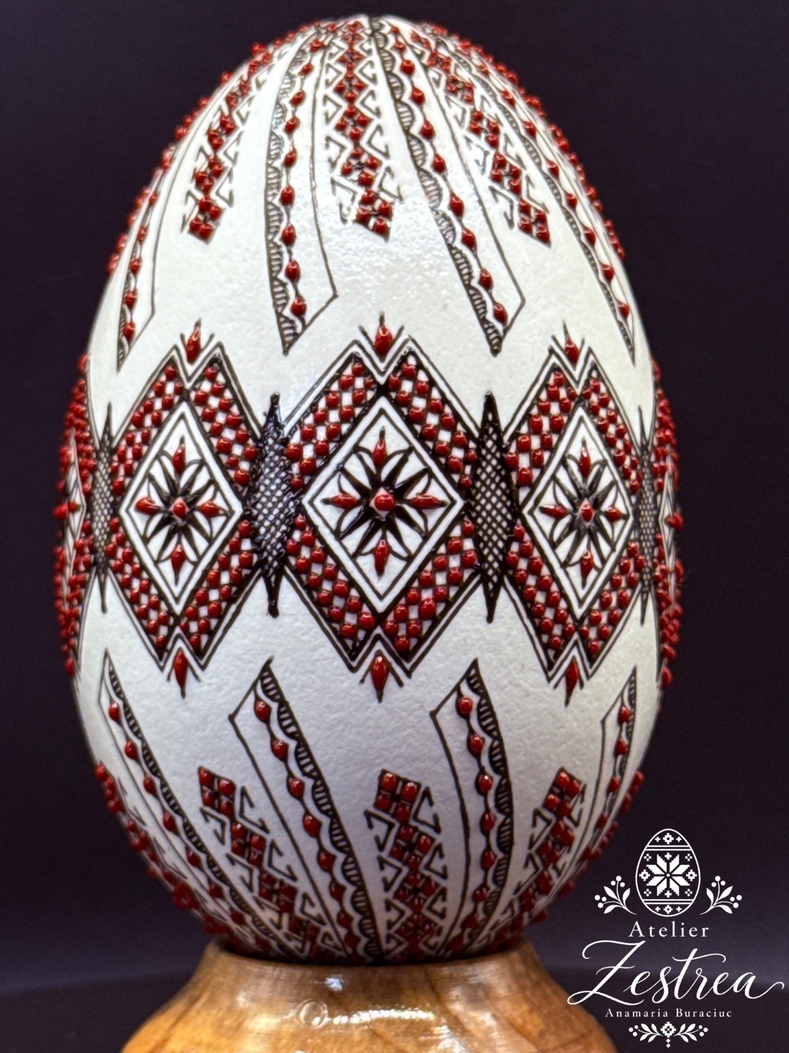 White goose egg with red-and-black diamonds and vertical ornamental chains