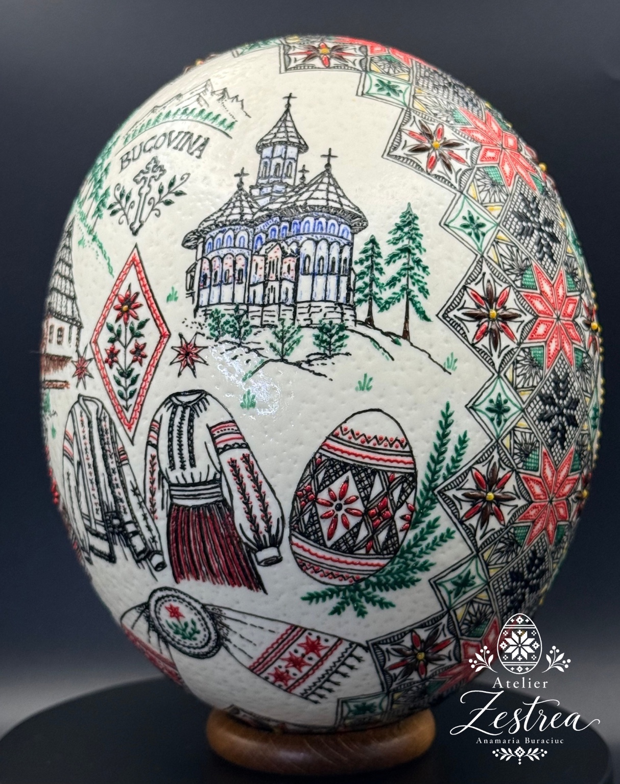 White ostrich egg decorated with a winter village, fir trees and red geometric motifs