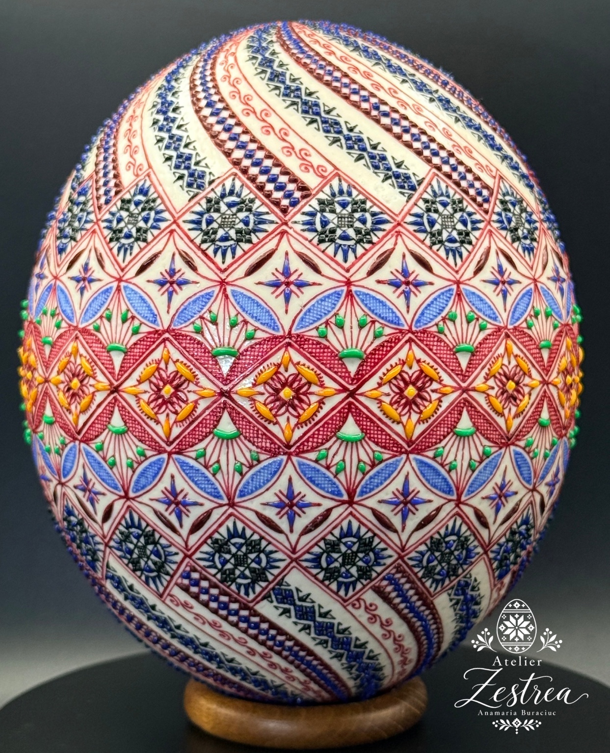 Ostrich egg covered with colourful stars, diamonds and diagonal ornamental bands