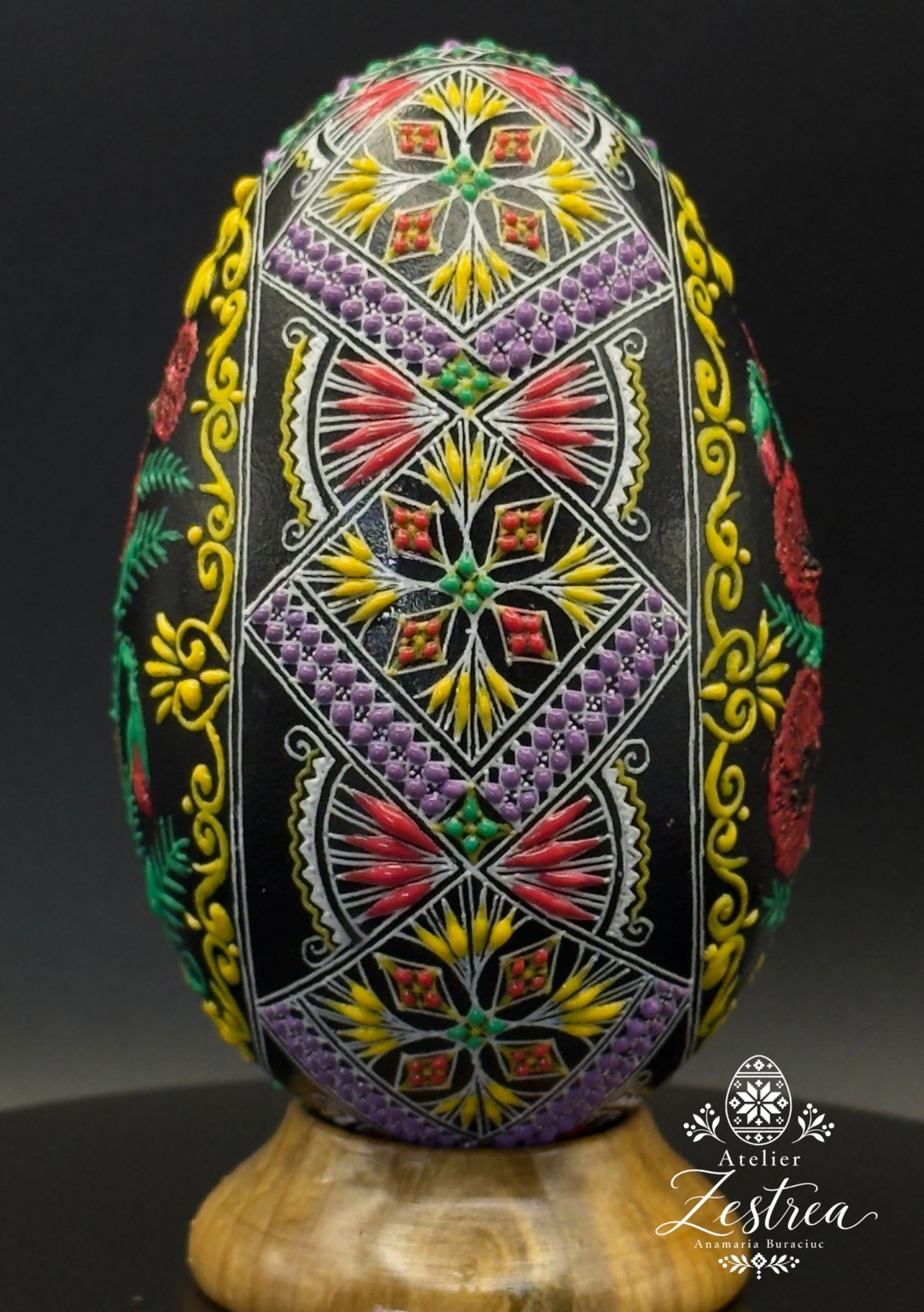Black goose egg with colourful diamond bands and yellow scroll motifs